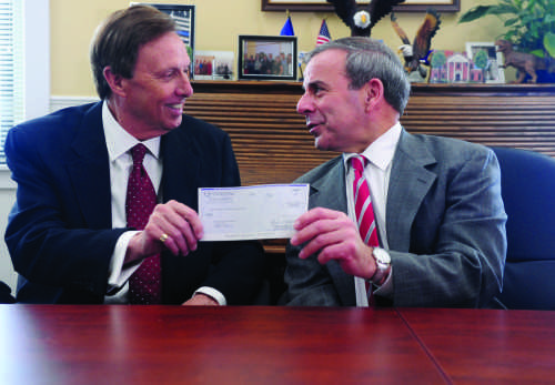 Quinnipiac University President John Lahey presents North Haven First Selectman Michael Freda with a $400,000 check Tuesday, Feb. 1, 2016, at North Haven Town Hall. The annual voluntary contribution to the town is a show of support and partnership between the university and the town.