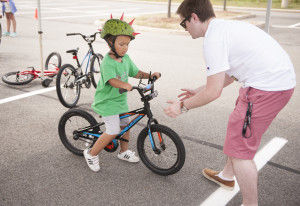 Four-and-a-half-year-old Santino Iamunno, of North Branford, gets one-on-one bike riding instruction from Ian Zane, of Zane's Cycles in Branford, on the second day of Camp No Limits Friday, July 8, 2016, on Quinnipiac University's York Hill Campus. (Photograph by Autumn Driscoll / for Quinnipiac University)